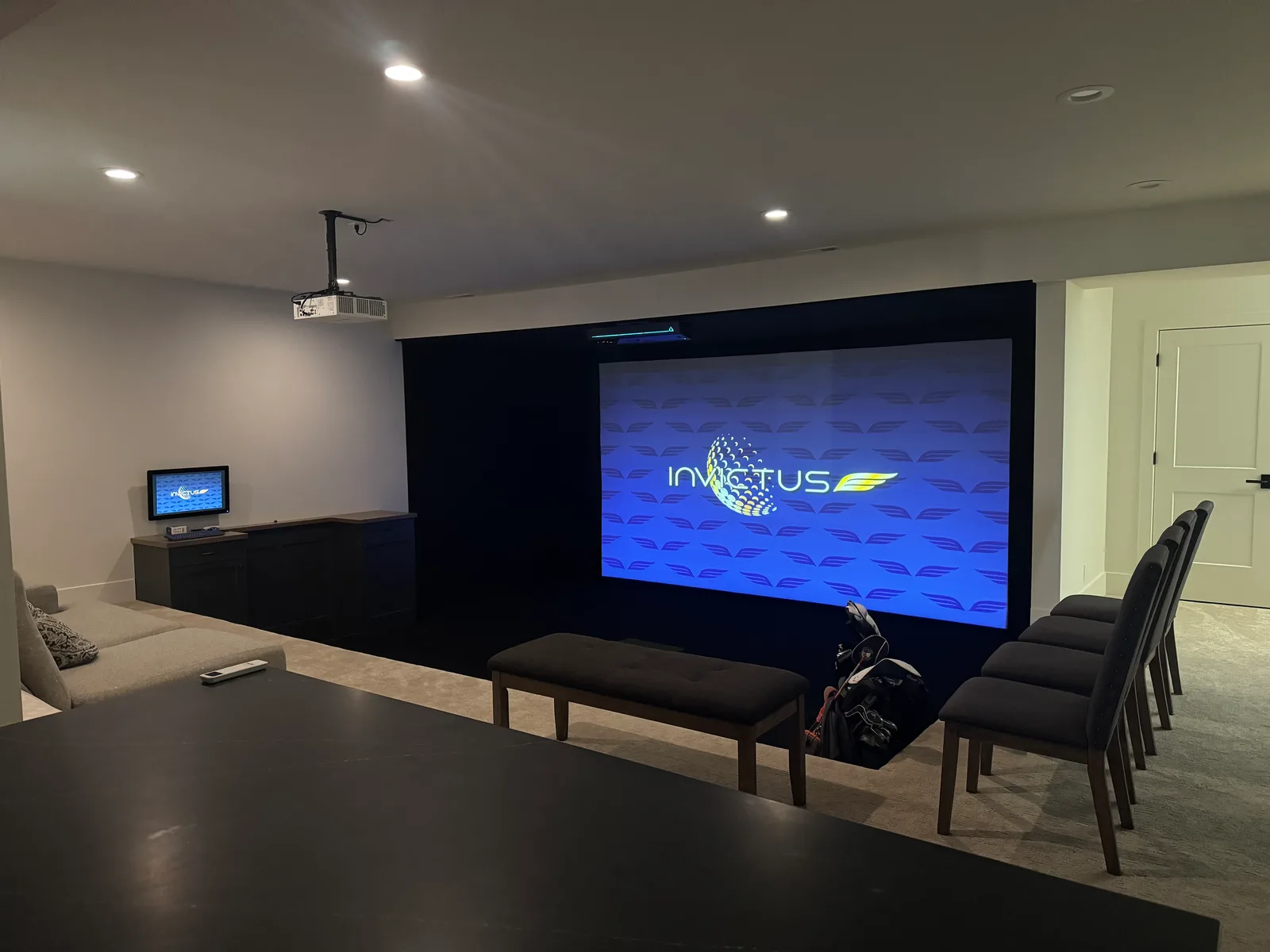 Basement simulator room with wide impact screen and seating